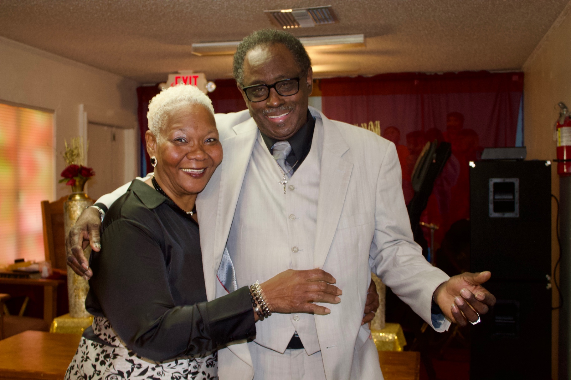 An elegantly dressed couple posing together in the church sanctuary